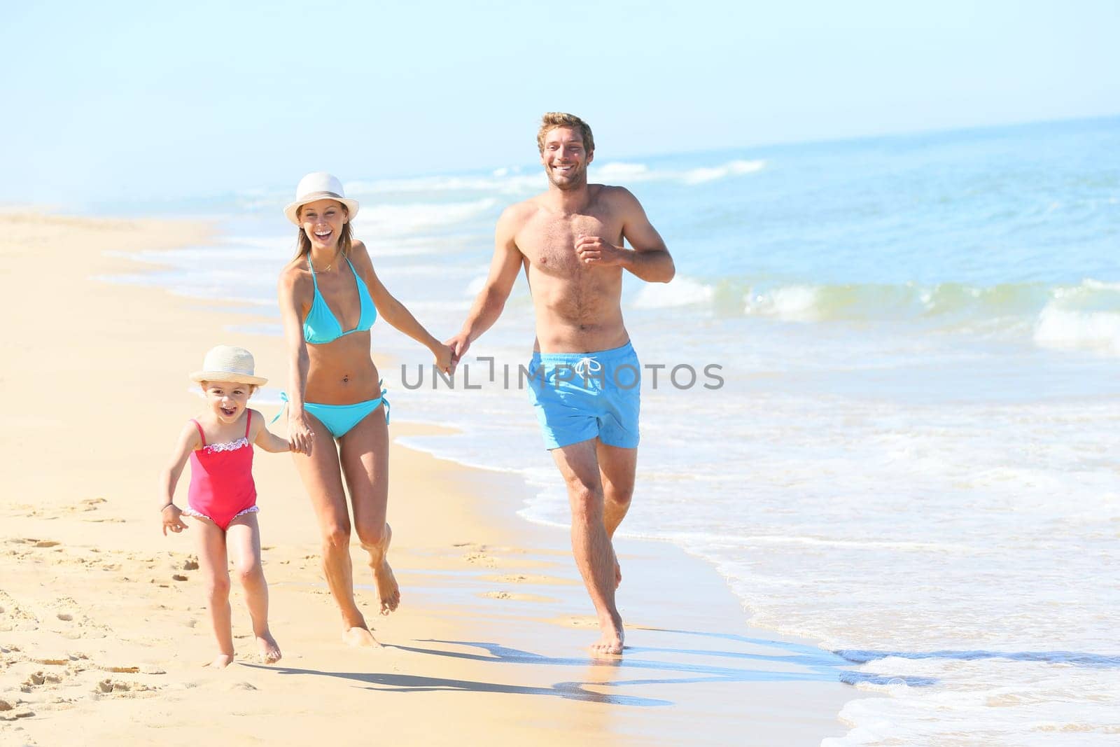 Family having fun running on a sandy beach