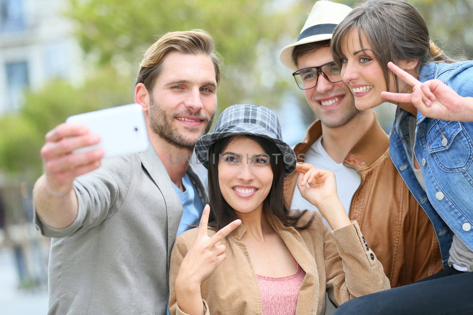 Group of friends taking picture of themselves with smartphone