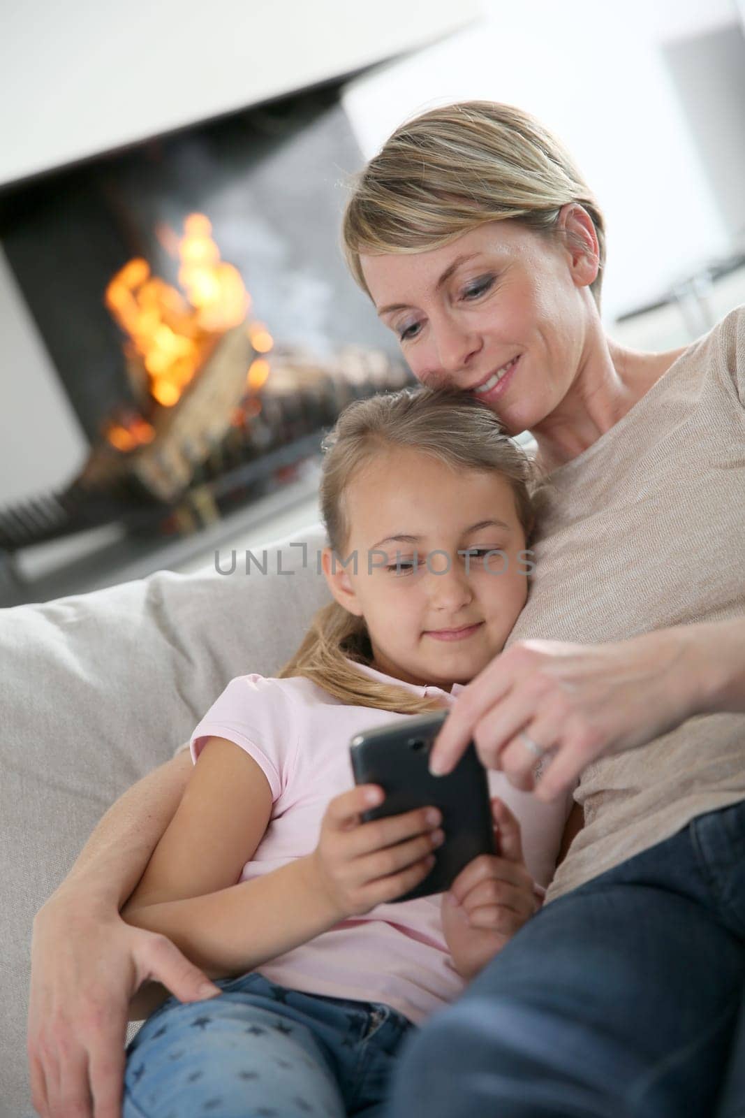 Mother and daughter playing together with smartphone