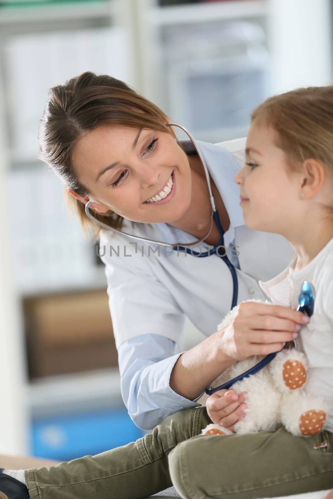 Doctor examining little girl with stethoscope