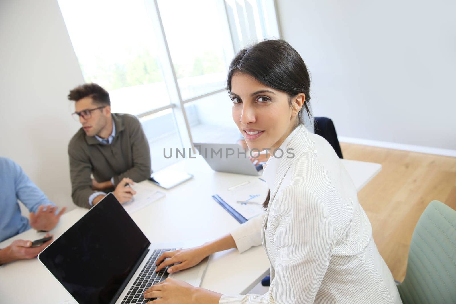 Businesswoman working on laptop, shared workspace