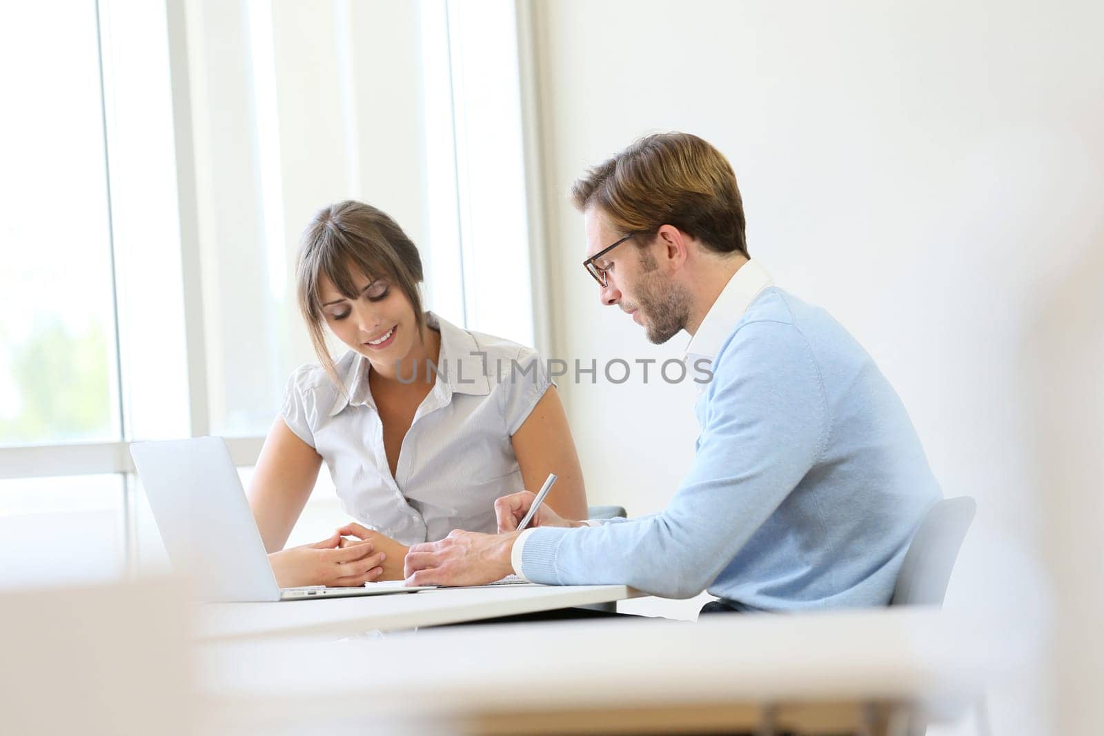 Colleagues working in modern office with laptop