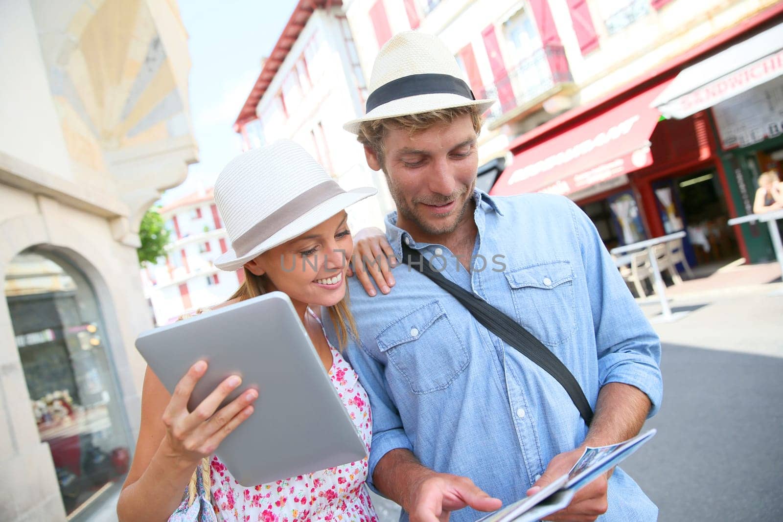 Couple in vacation looking at tourist guide on internet