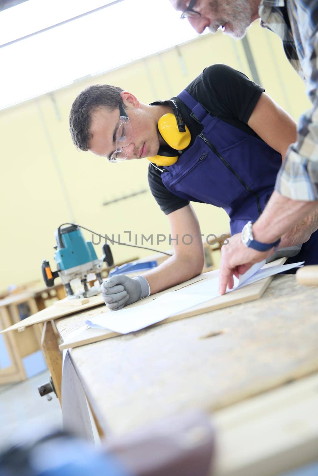 Carpenter with apprentice in training period