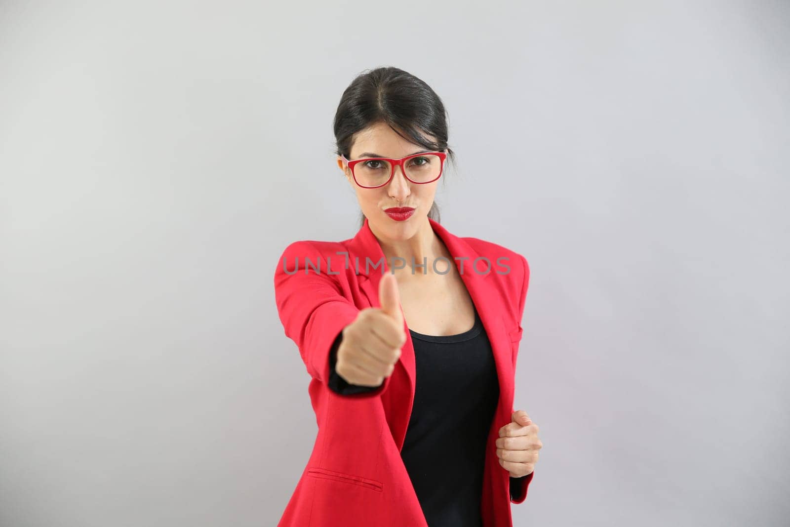 Beautiful brunette girl in red, showing thumbs up