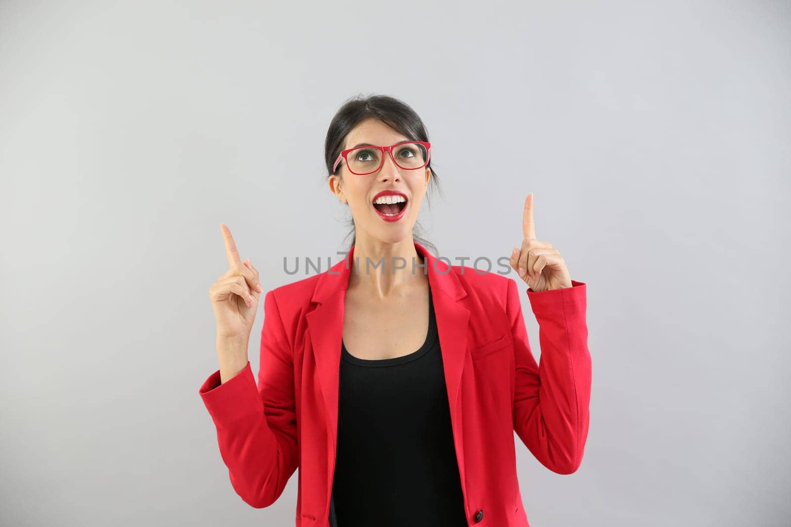 Beautiful brunette girl with red jacket pointing at message