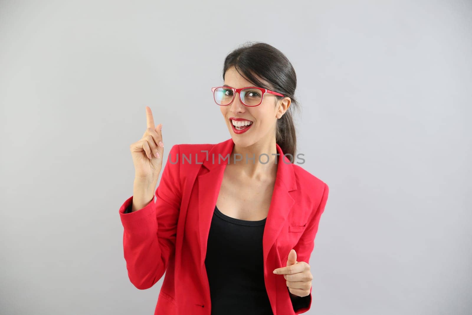 Beautiful brunette girl with red jacket pointing at message