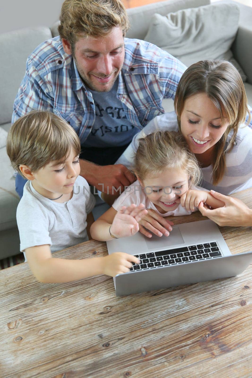 Parents with kids at home using laptop computer