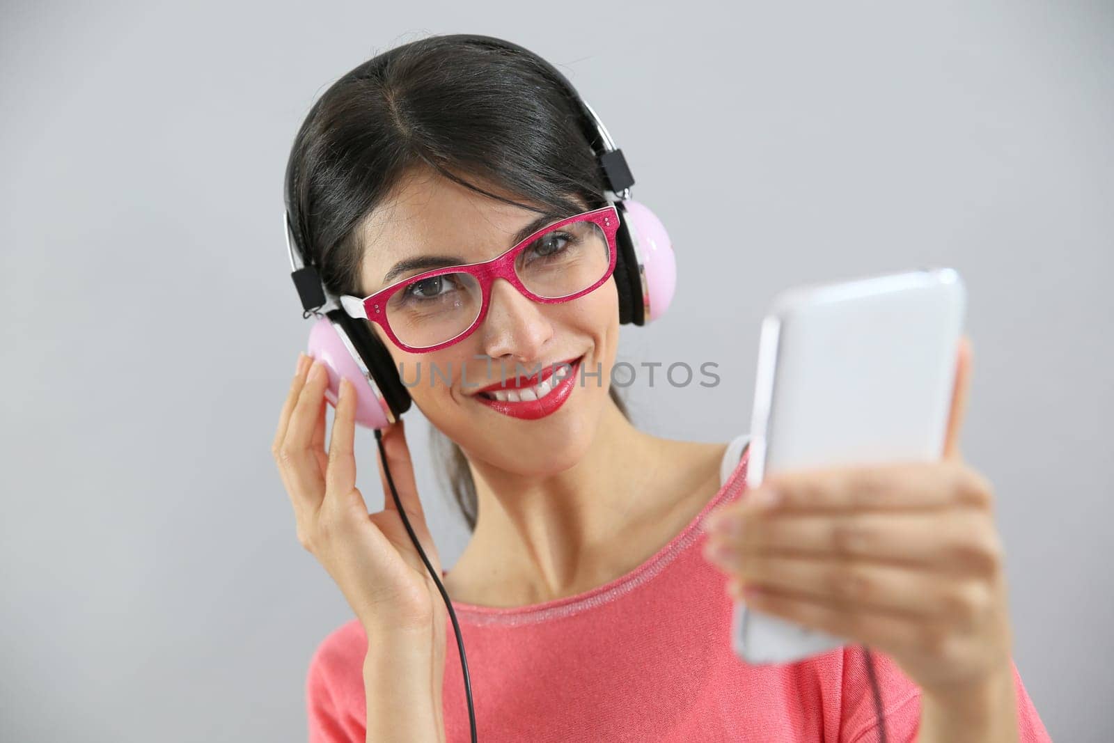 Brunette girl listening to music on smartphone, isolated