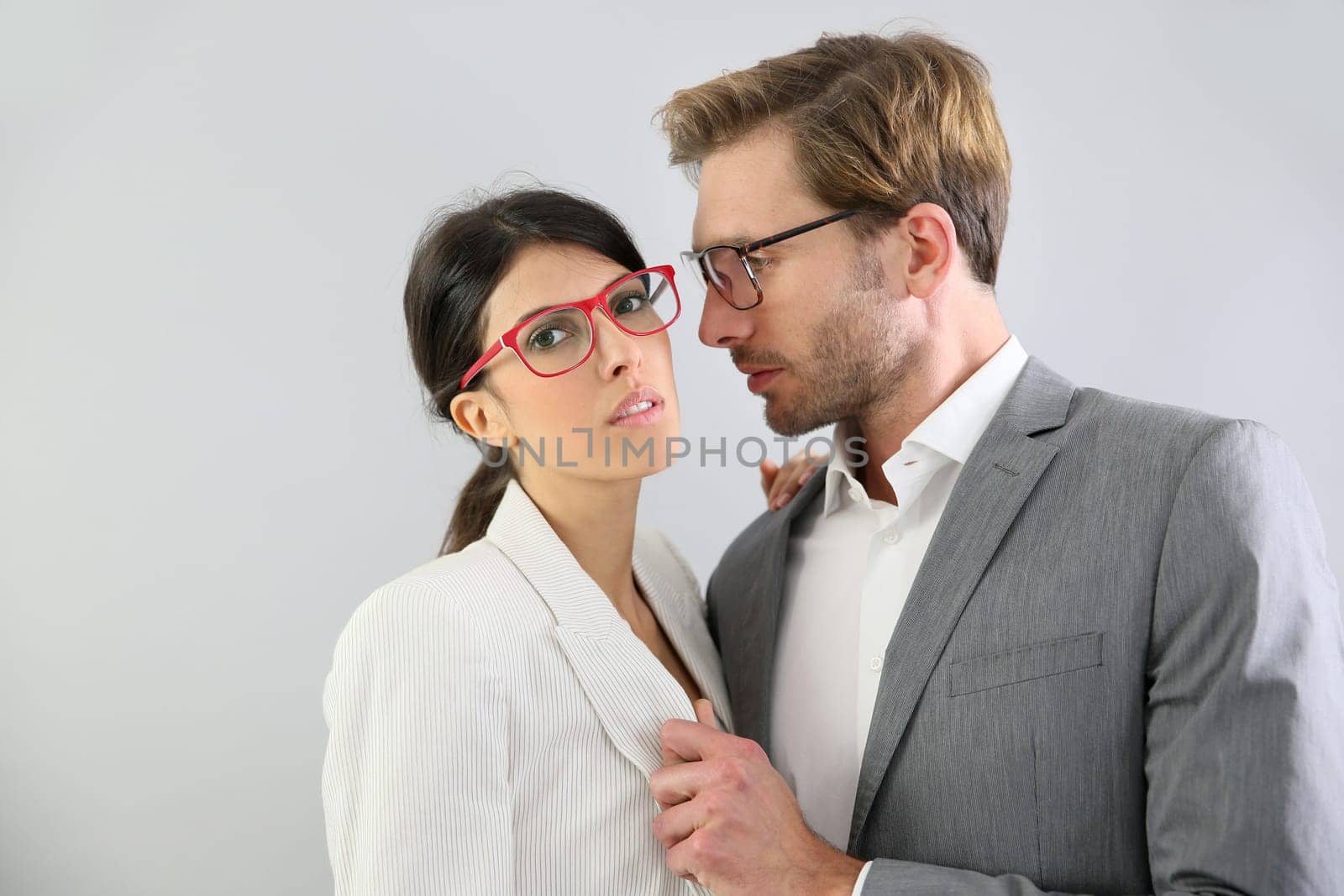 Business couple standing on grey background, isolated