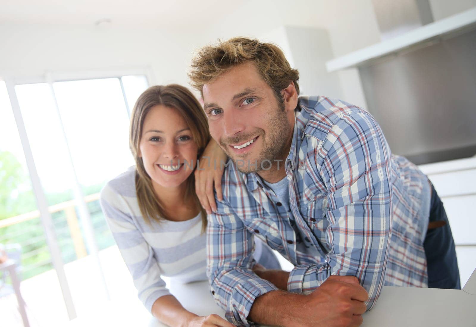 Portrait of couple standing in modern kitchen