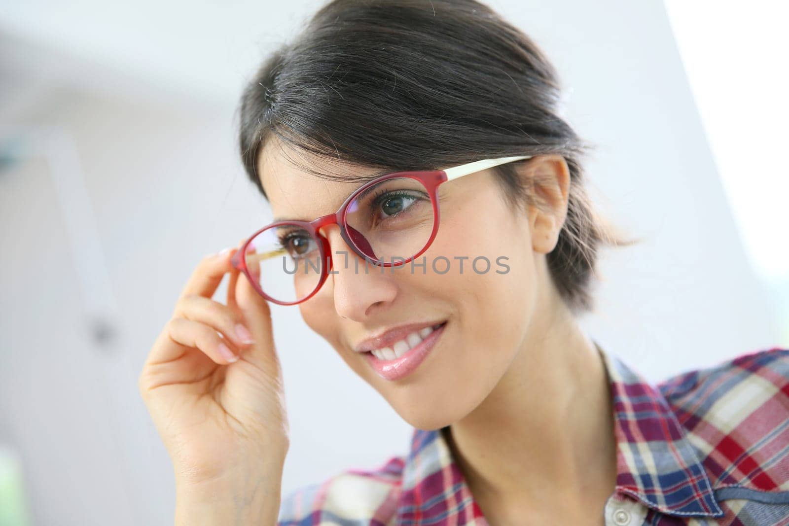 Portrait of brunette girl with red eyeglasses on, isolated