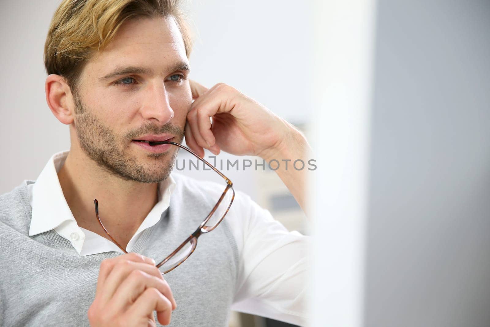 Businessman with eyeglasses sitting in front of desktop computer screen