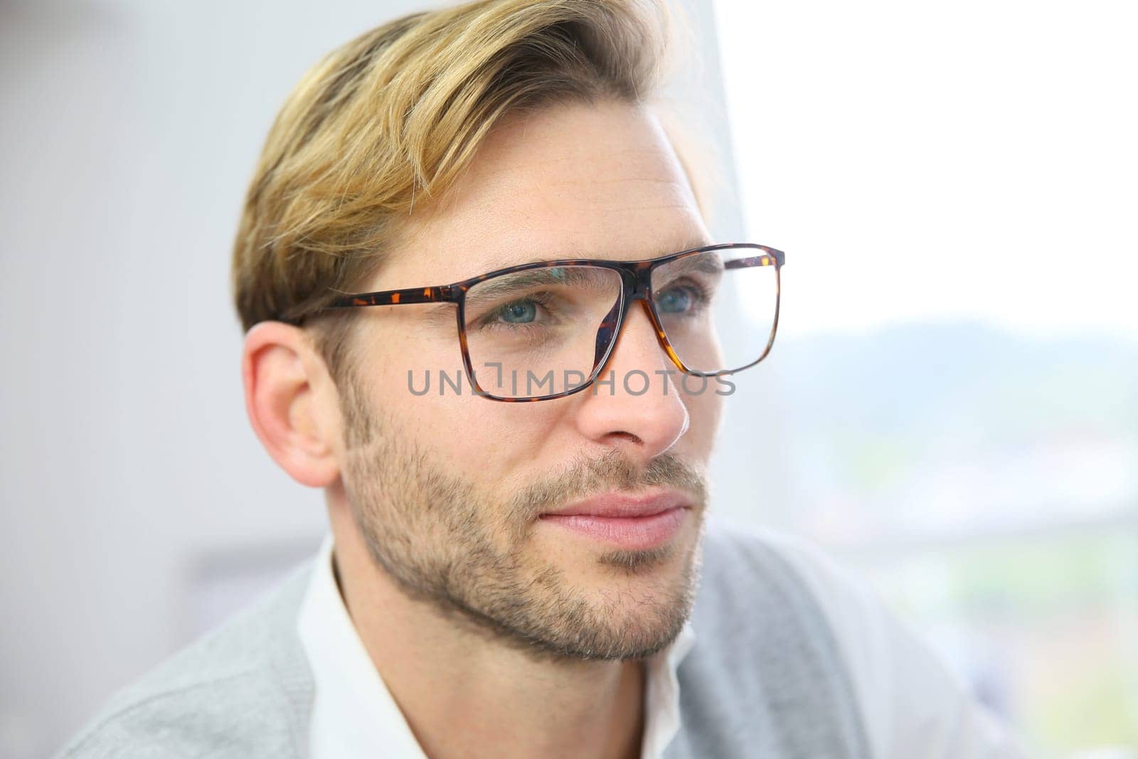 Businessman with eyeglasses sitting in front of desktop computer screen