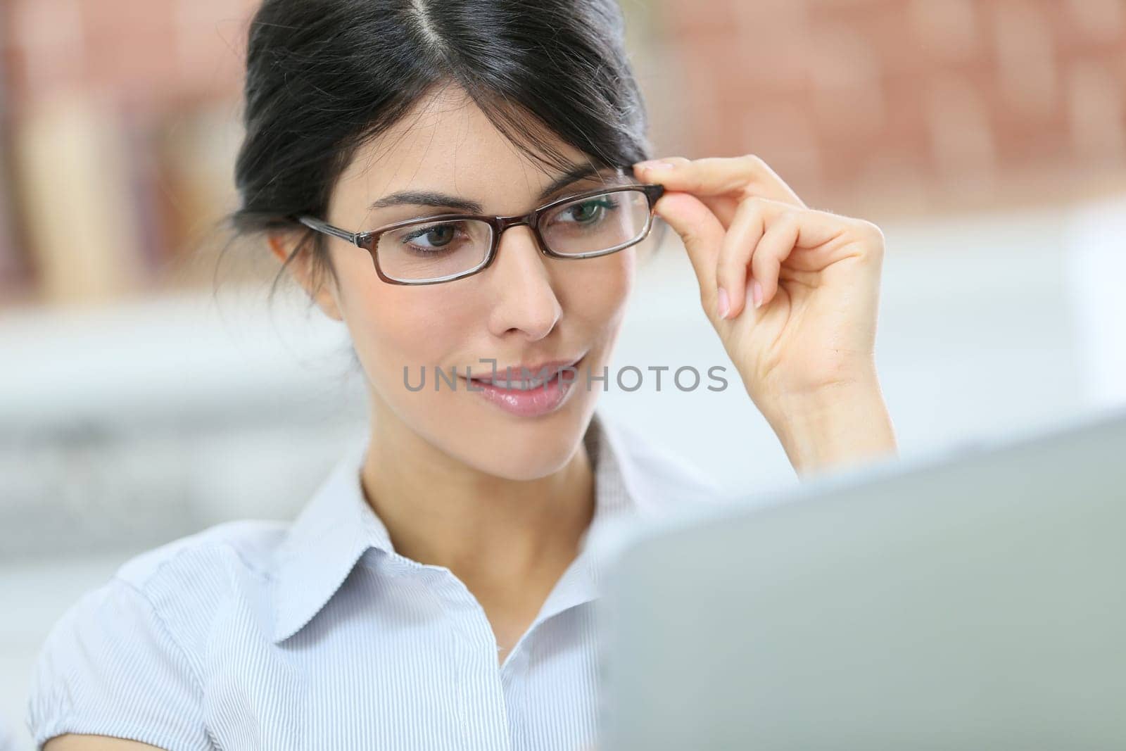 Young woman with eyeglasses using digital tablet