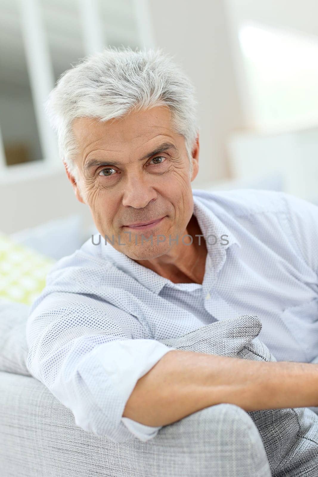 Portrait of elderly man relaxing in sofa at home