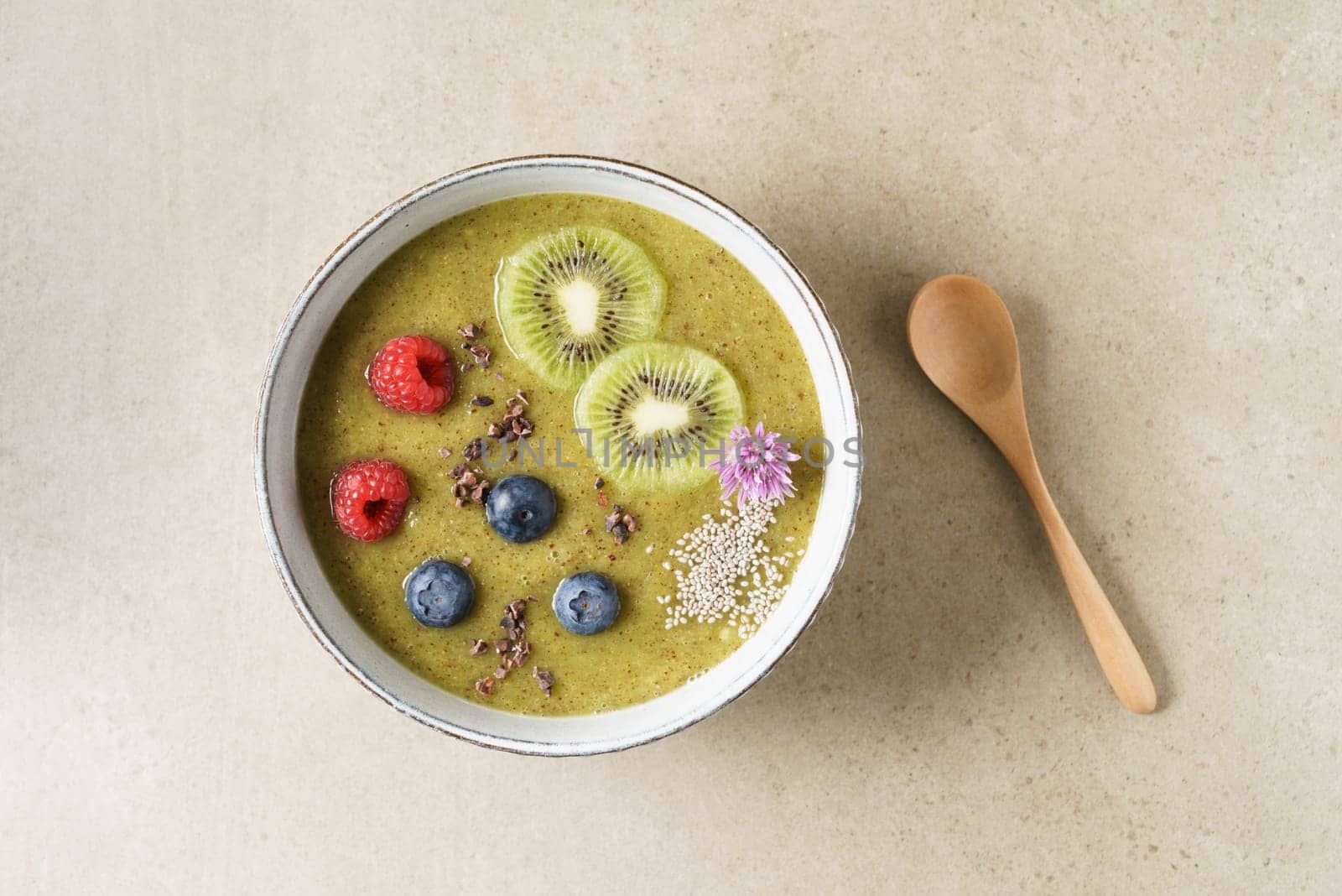 Kiwi smoothie bowl with blueberries, kiwi, white chia seeds and raspberries in a bowl