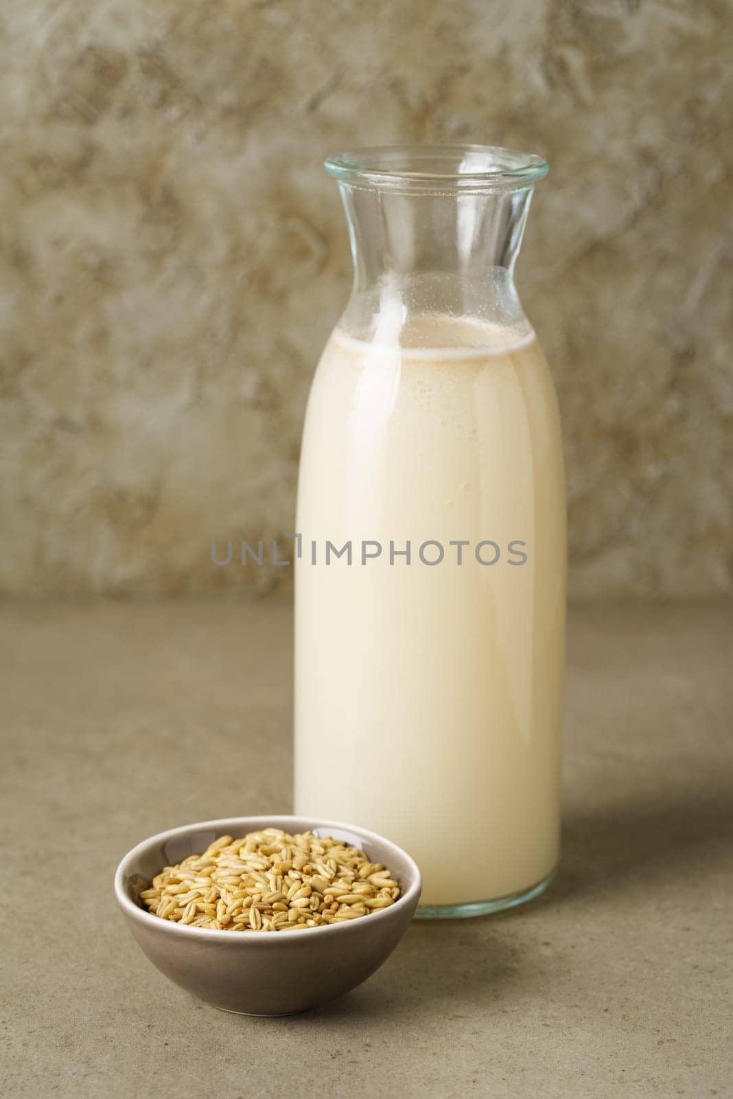 Fresh homemade oat milk in a bottle with oats