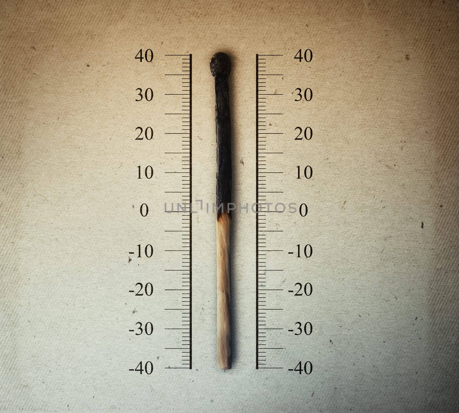 Burned match indicating temperature on a scale as a thermometer. Global warming and temperature rising concept