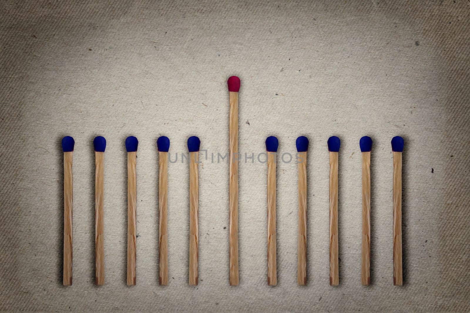 Red match standing middle a row of blue ones. Standing out from the crowd, leadership, difference concept