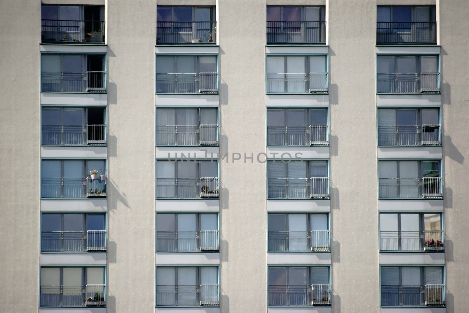 A multi-storey residential building with terraced windows and railings.