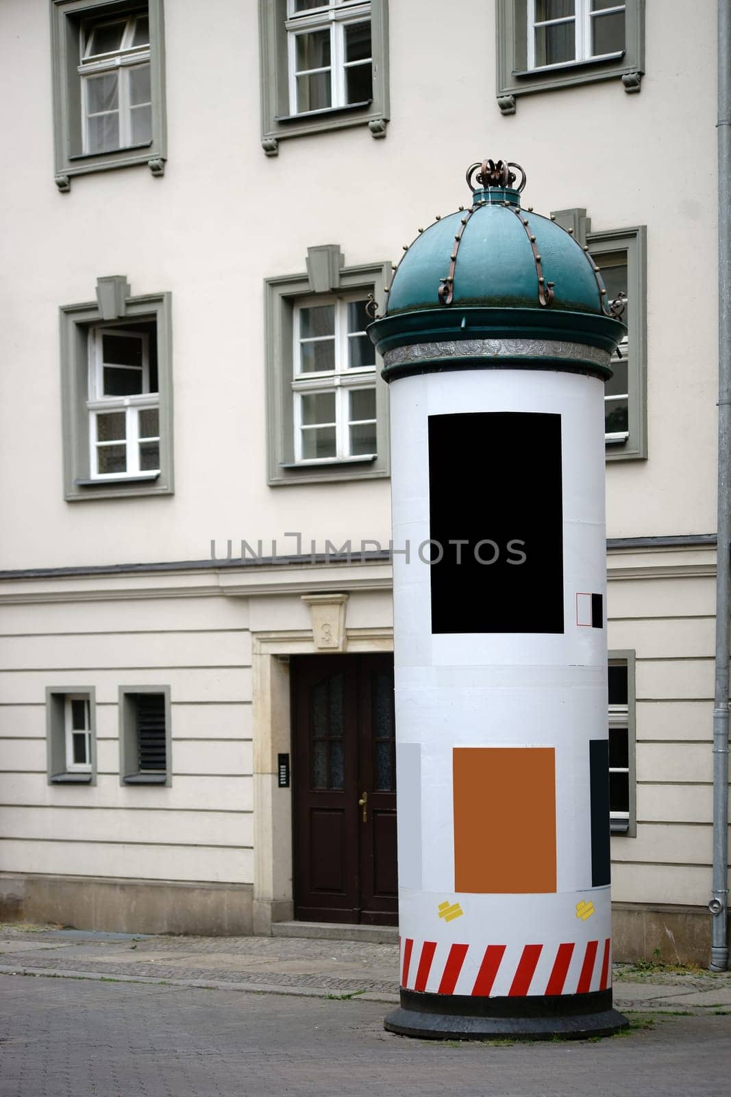 A column with posters and posters in the city center of Berlin and with a lace bent to the crown.
