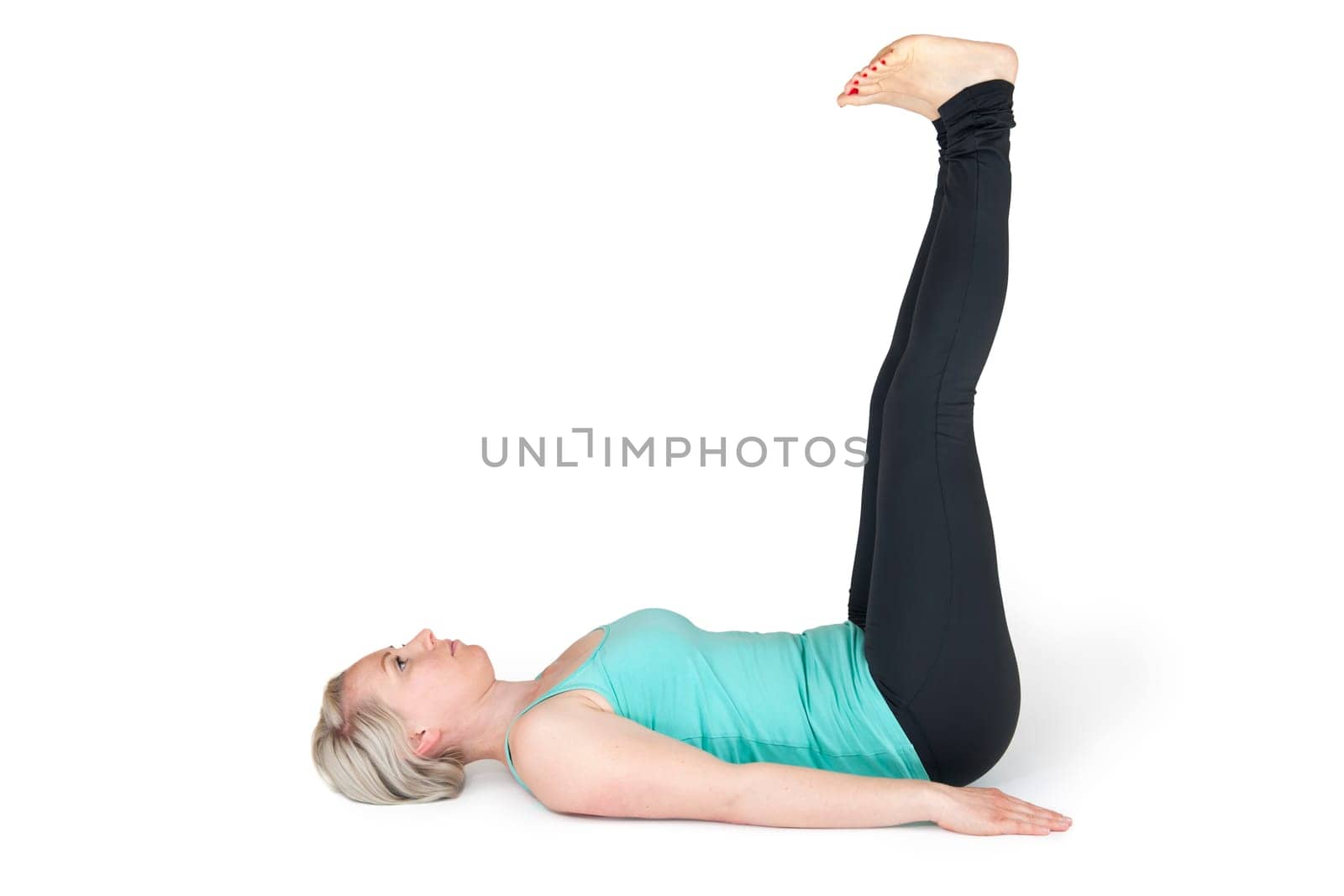 Full body view of a young blonde woman doing yoga exercises against a white background with a slight shadow