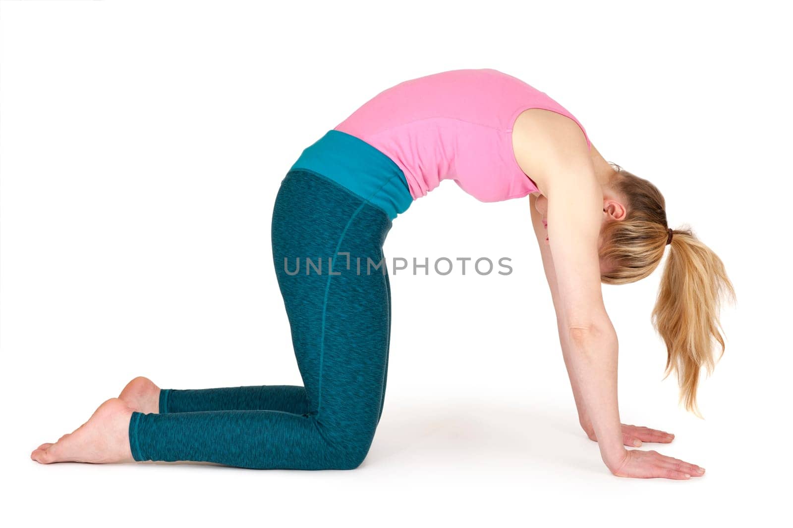 Full body view of a young blonde woman doing yoga exercises against a white background with a slight shadow
