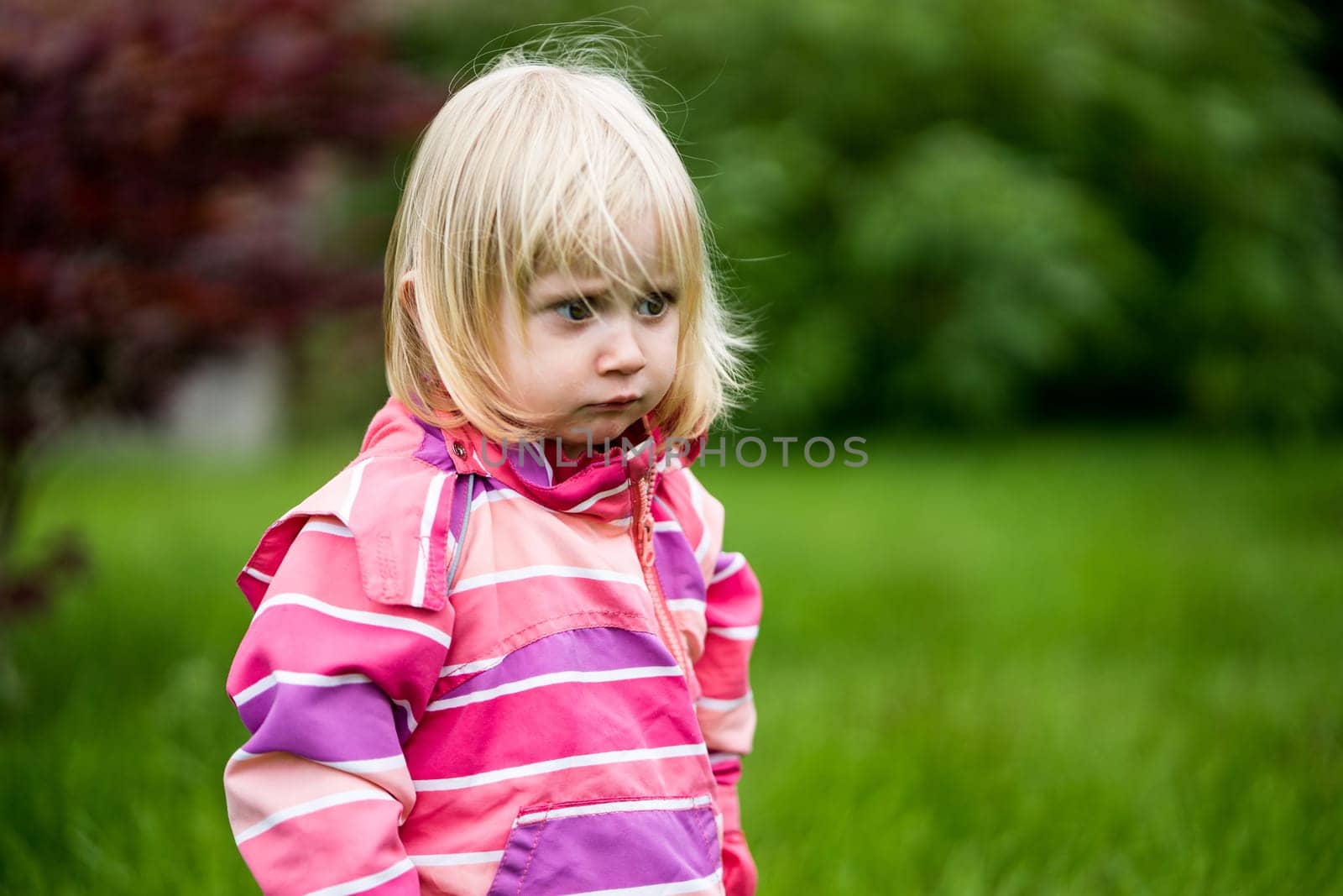 Sad or bewildered girl standing alone in the garden