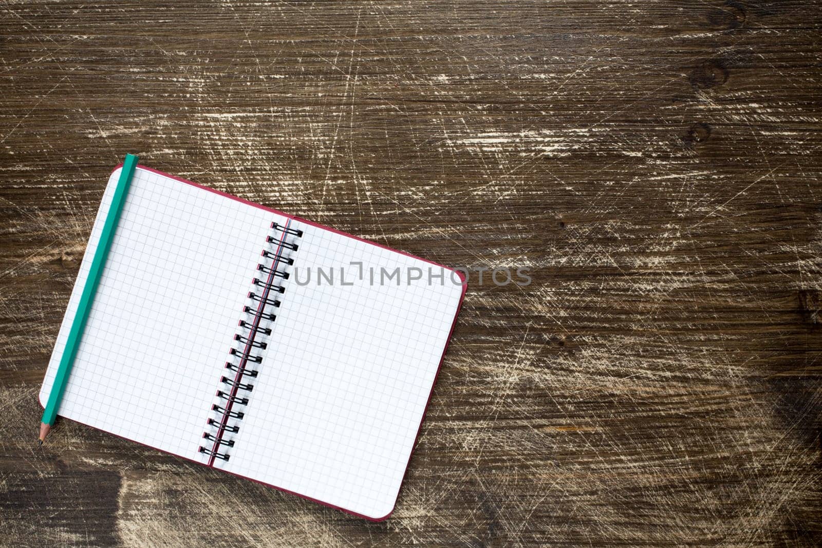 Open spiral notebook on the wooden background.Top view,copy-space.