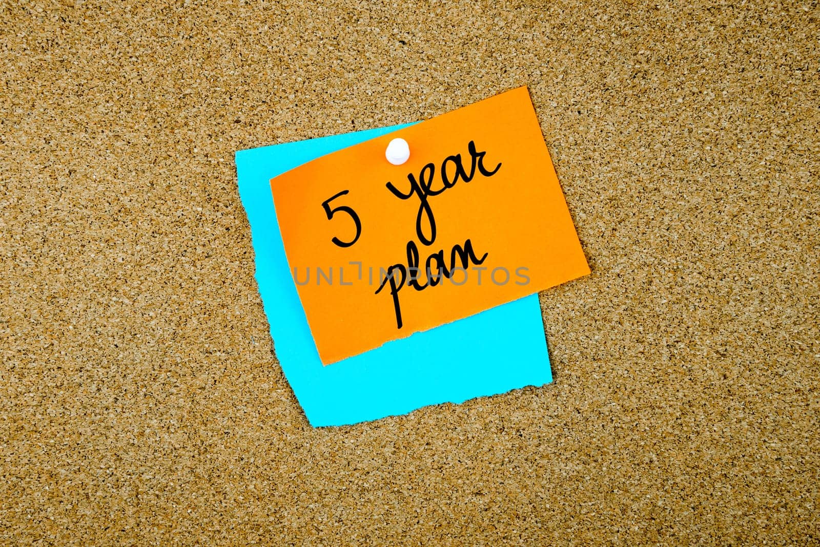 Five Year Plan written on paper notes pinned on cork board with white thumb tack, copy space available