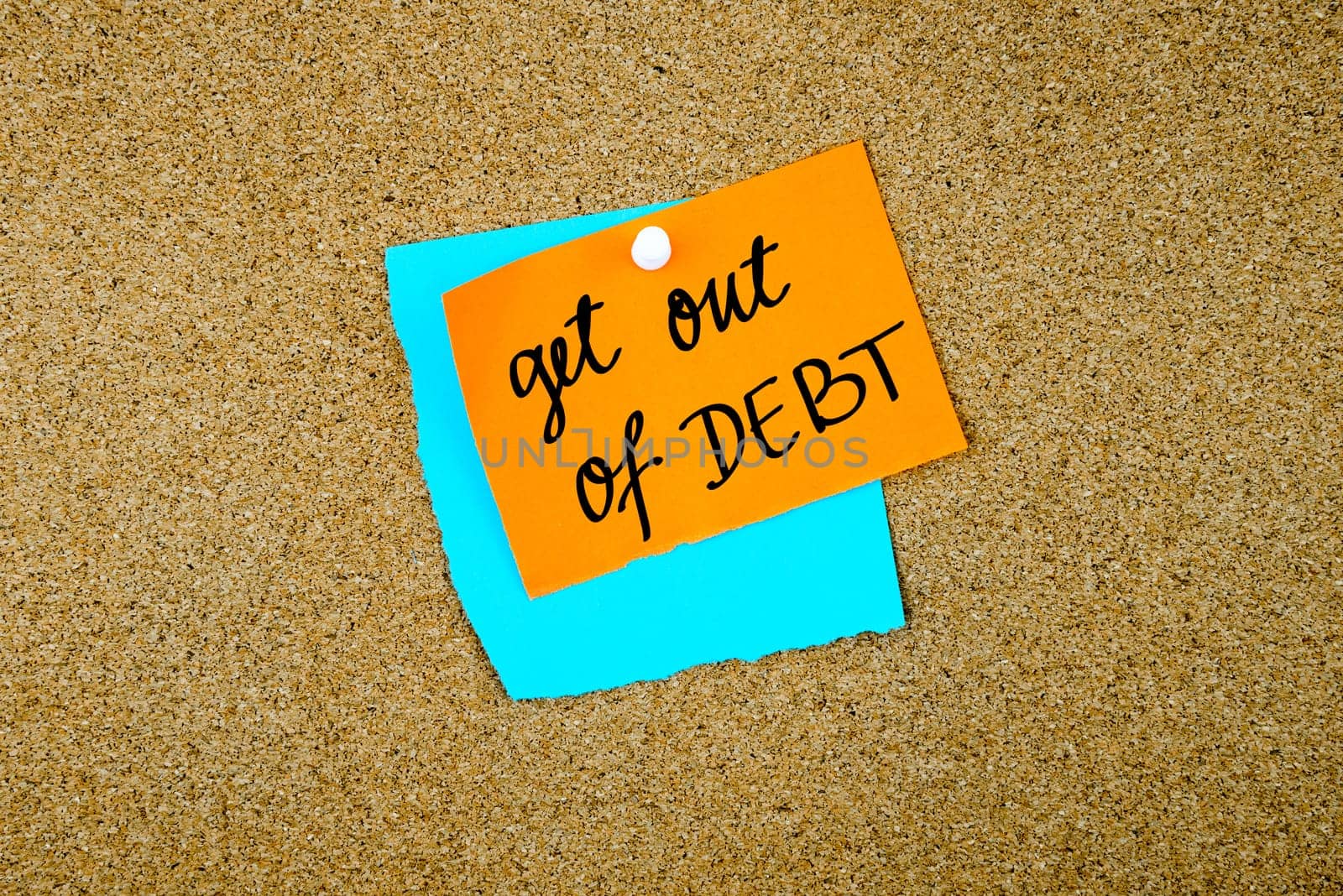 Get Out Of Debt written on paper notes pinned on cork board with white thumb tack, copy space available