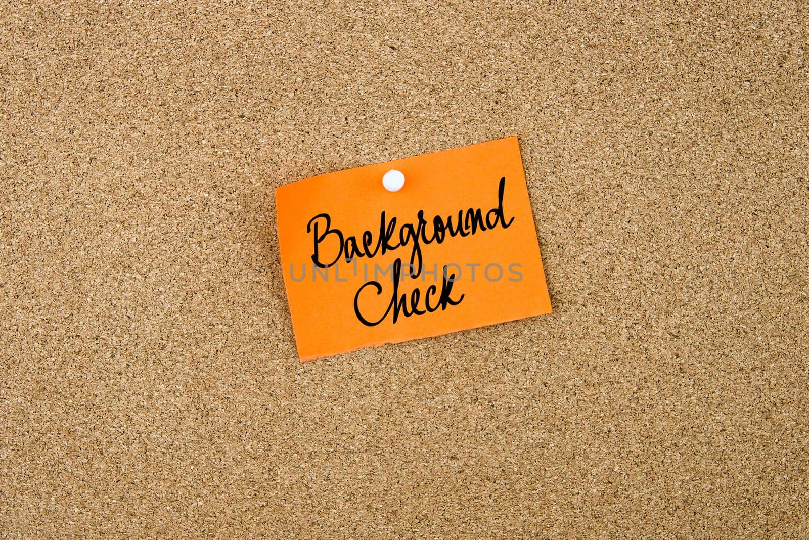 Background Check written on orange paper note note pinned on cork board with white thumbtack, copy space available