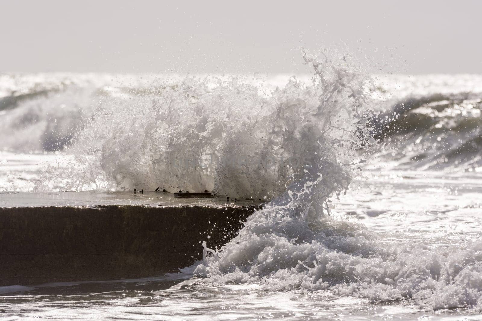Waves breaking on the concrete pier