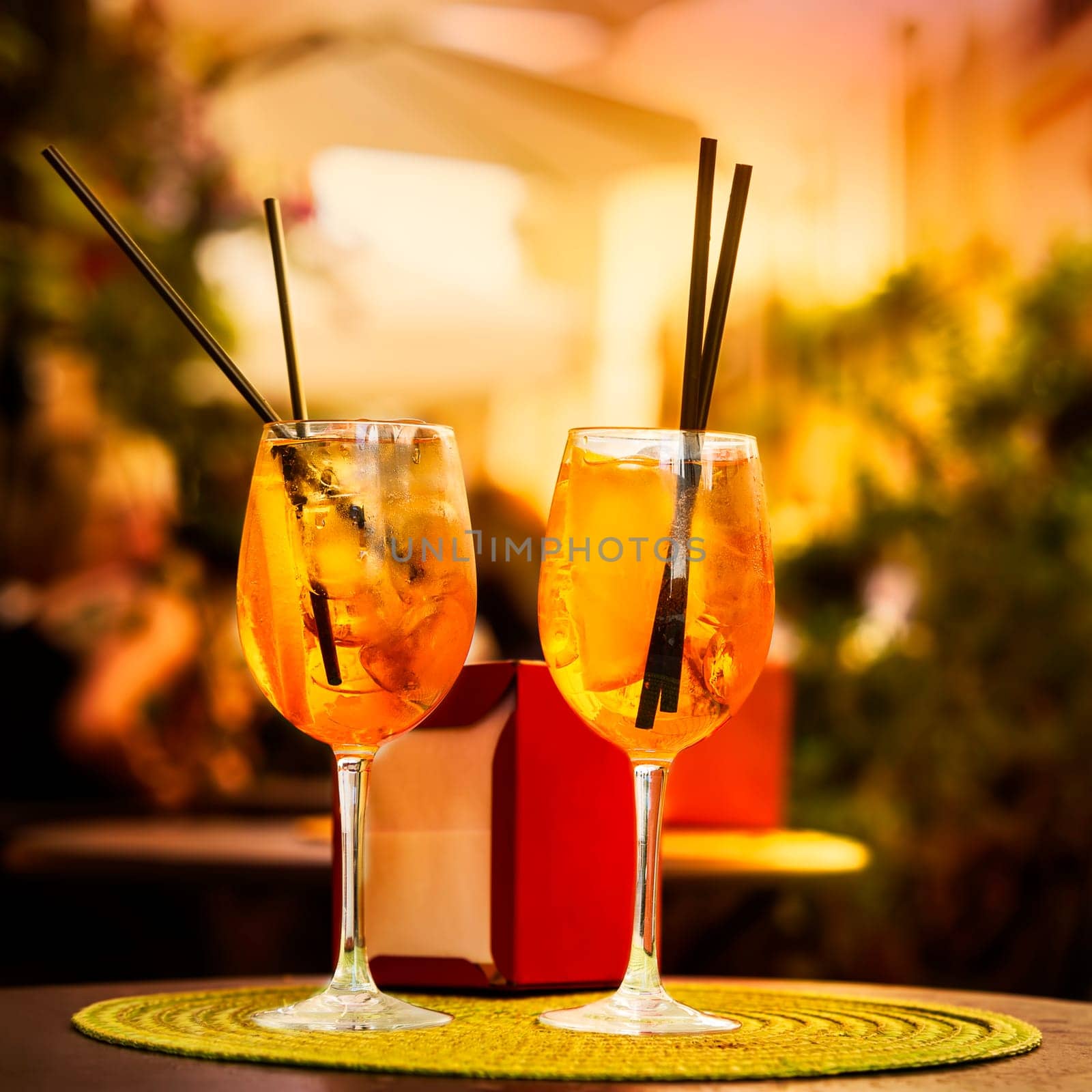 Aperol Spritz Cocktail. Alcoholic beverage based on table with ice cubes and oranges.