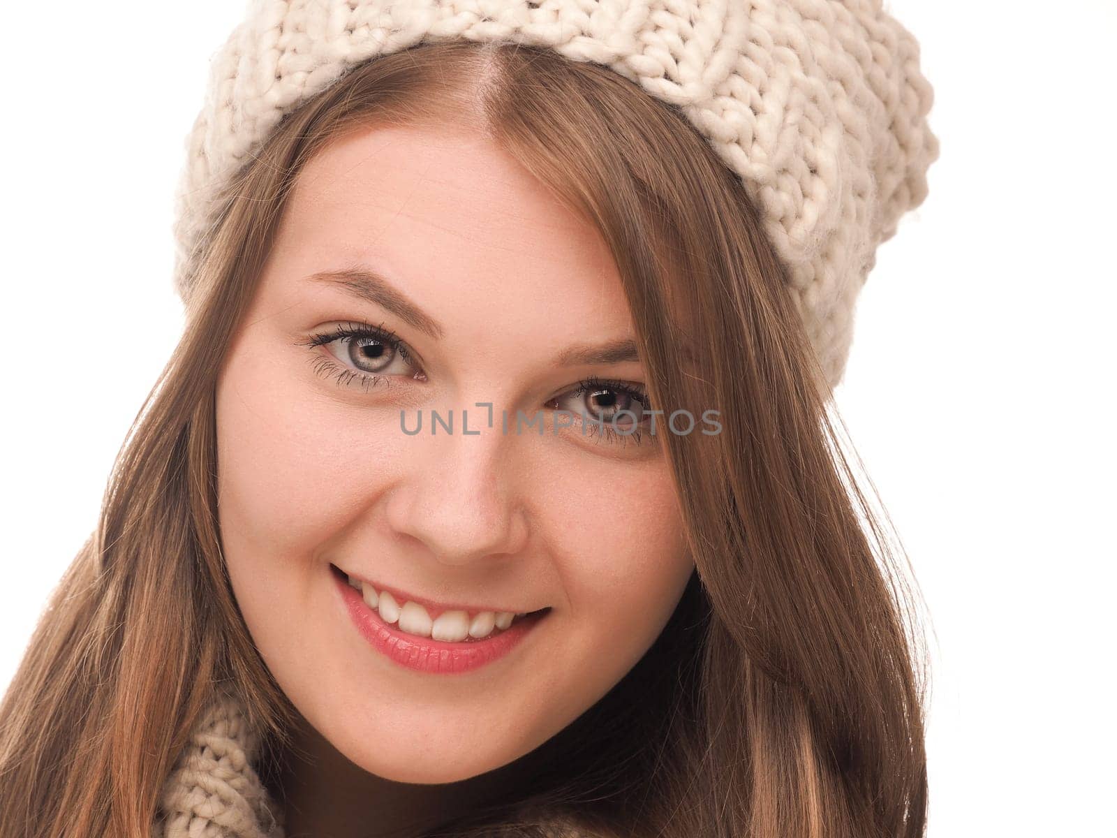 Attractive teenage girl dressed with wool cap and scarf on a white background