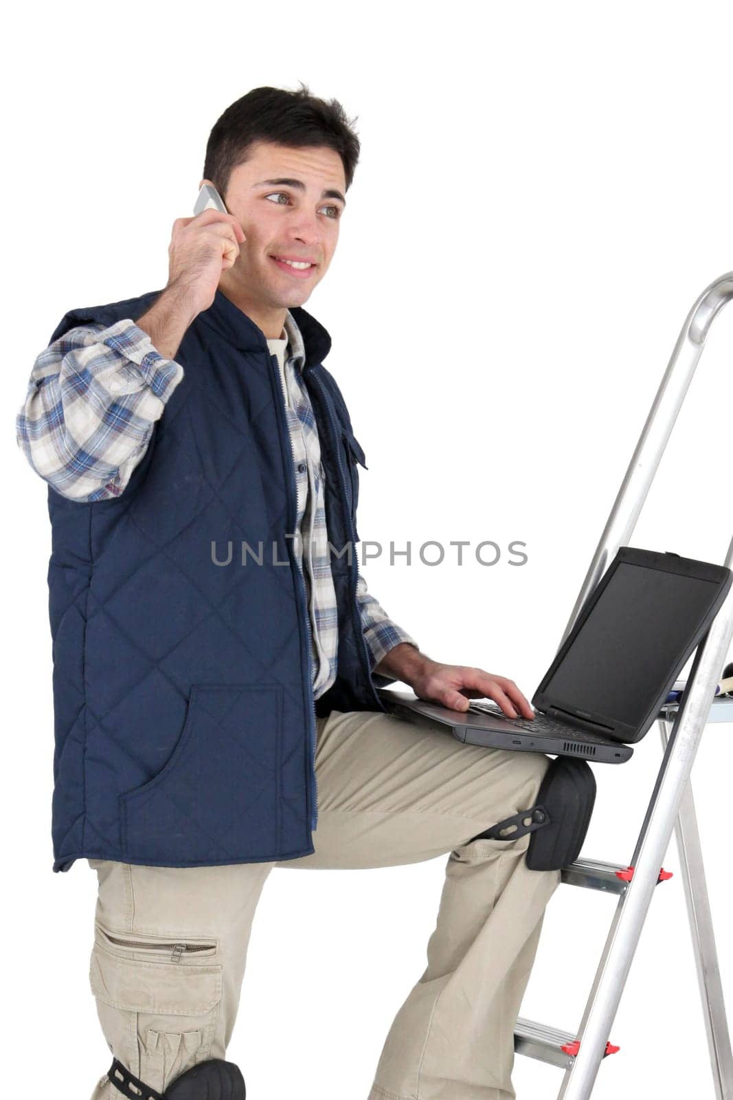 Decorator making telephone call whilst using laptop