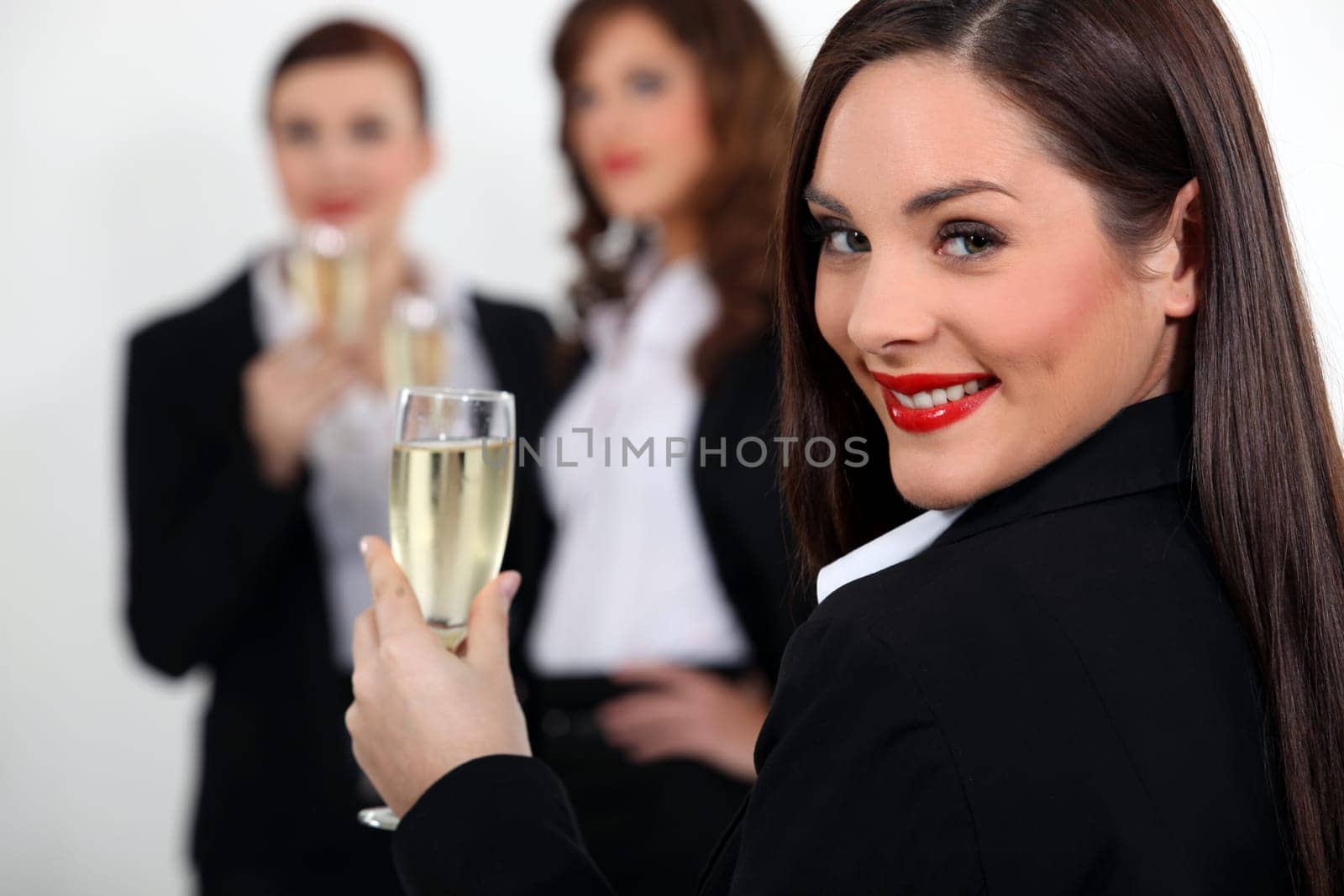 three business women drinking sparkling wine