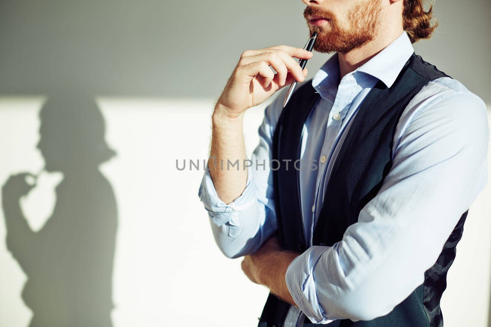 Thoughtful businessman touching chin with pen