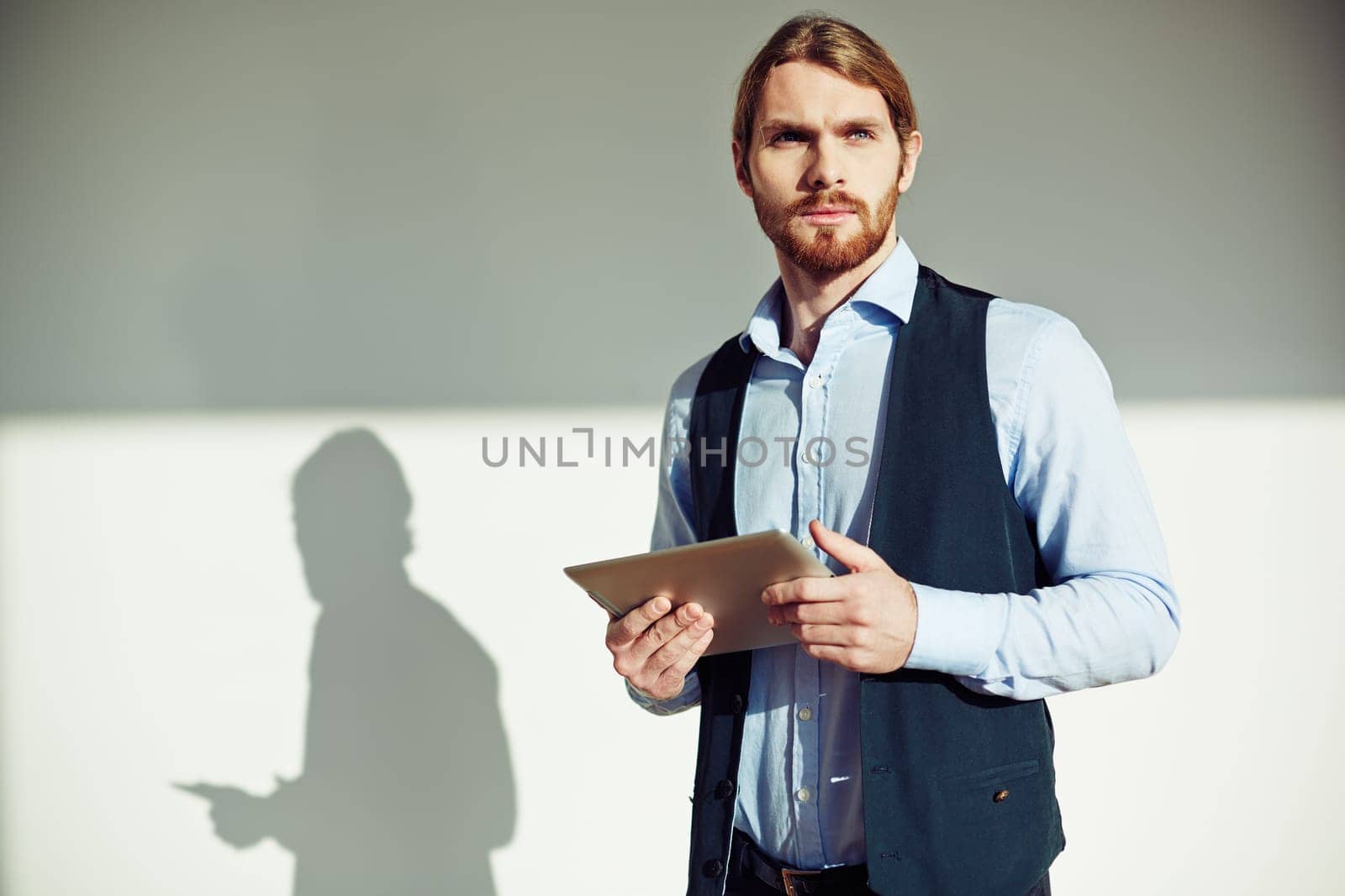Portrait of pensive businessman with touchpad