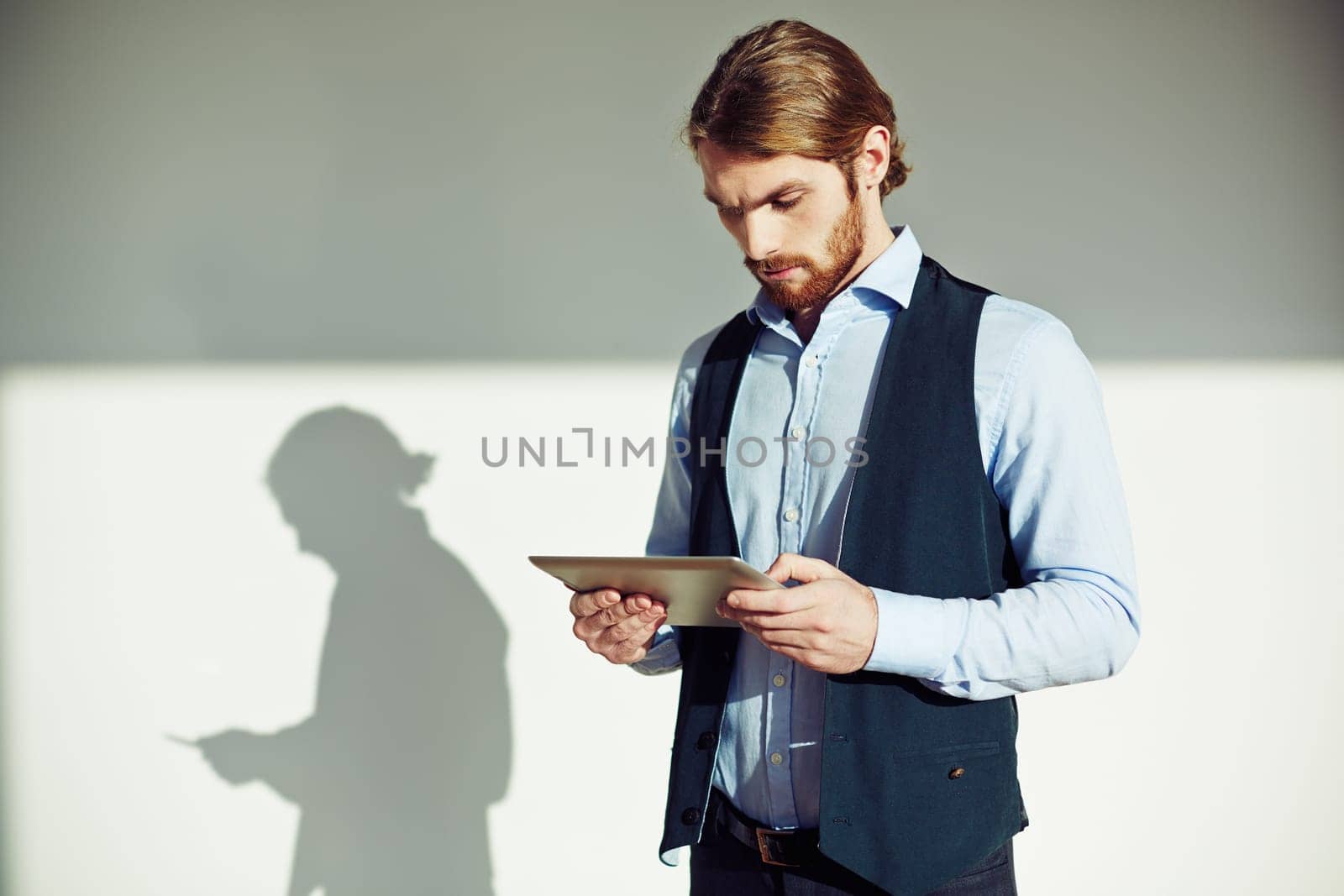 Young businessman with touchpad analyzing data