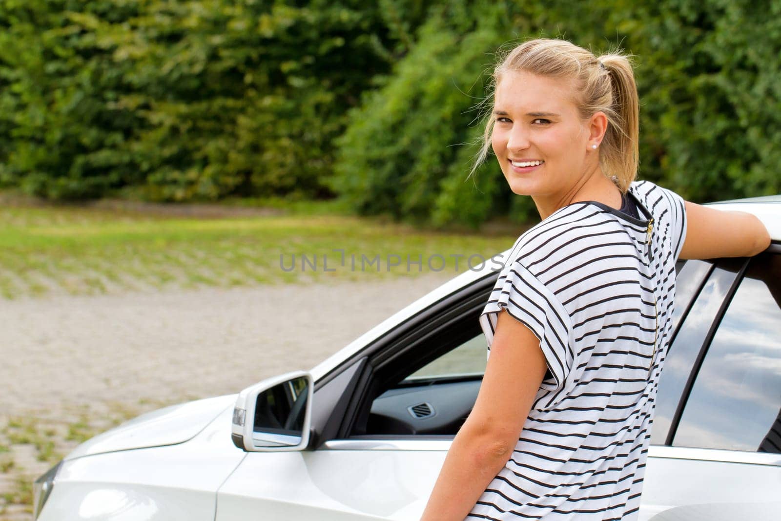 Young woman in front of her car