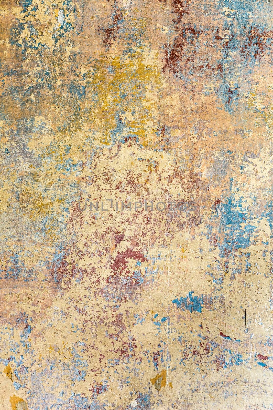 old grunge wall of an old house with remainings of color