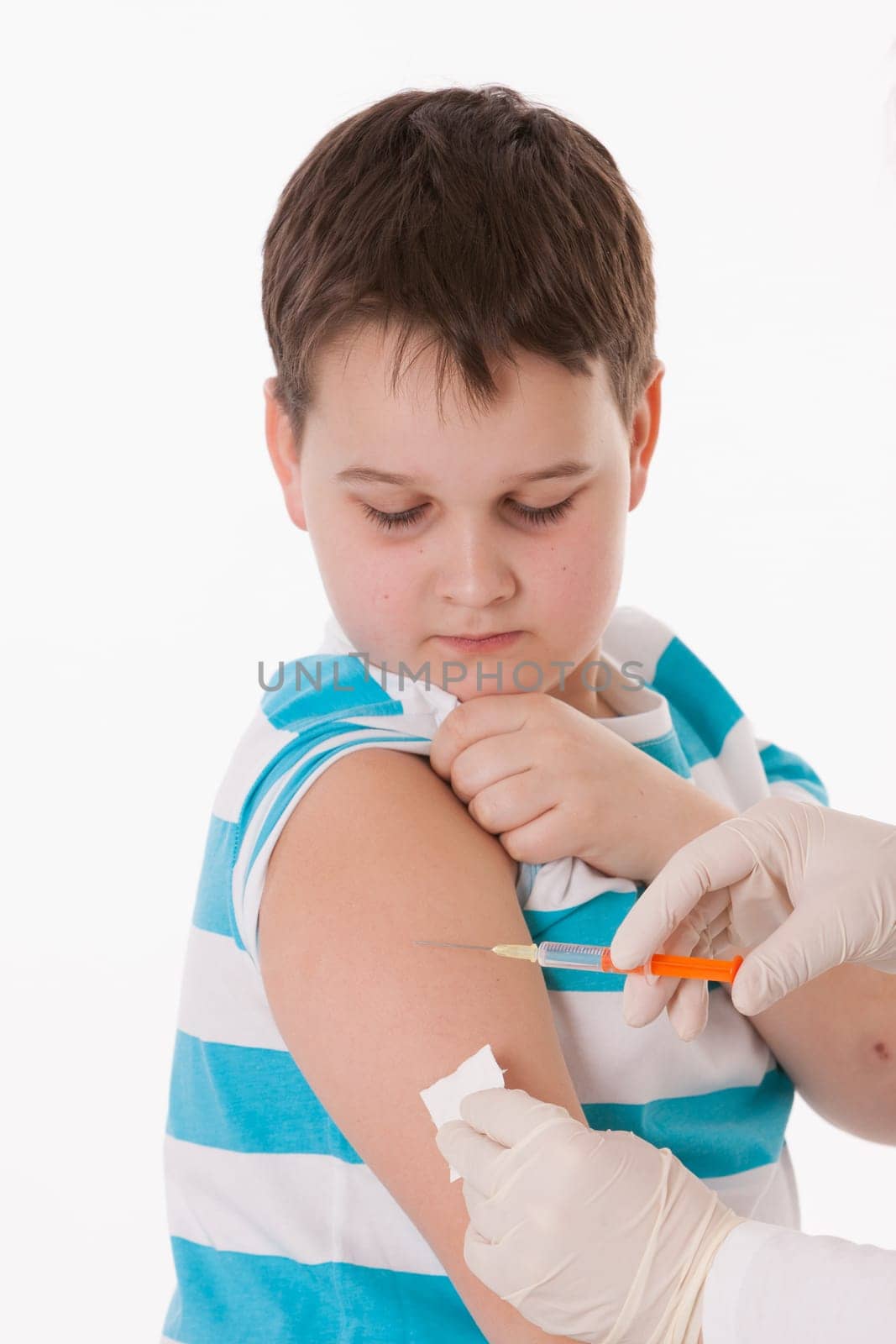 Doctor giving a child injection in arm on isolated image.