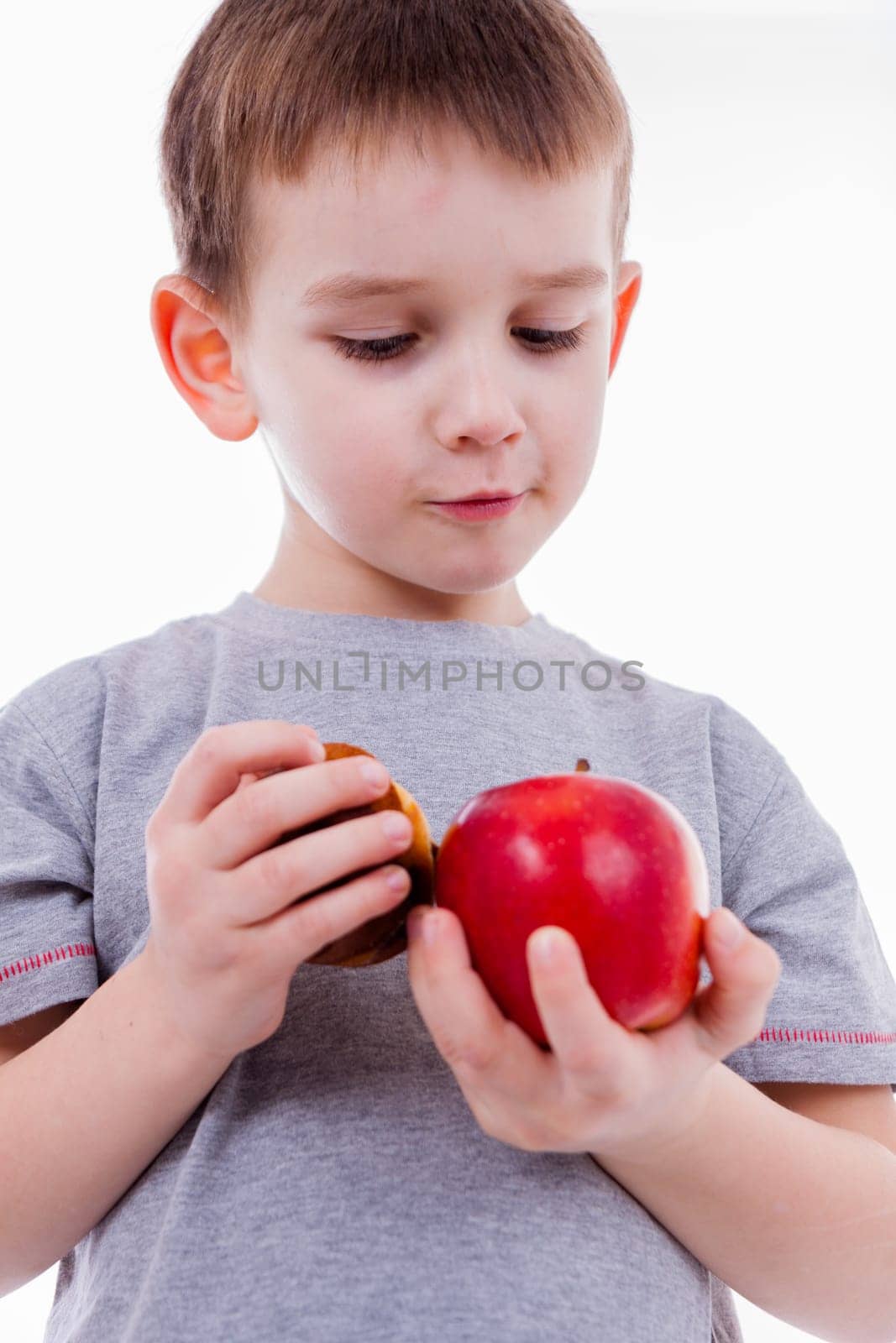 little boy with food isolated on white background - apple or a muffin