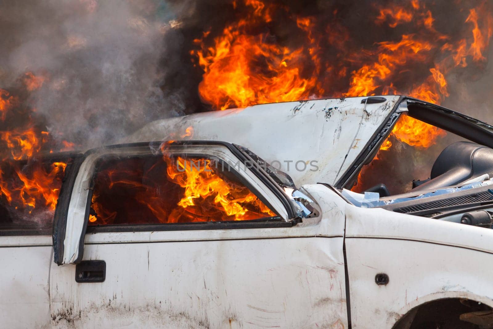 burning and then extinguish an old white car - Exercise firefighters