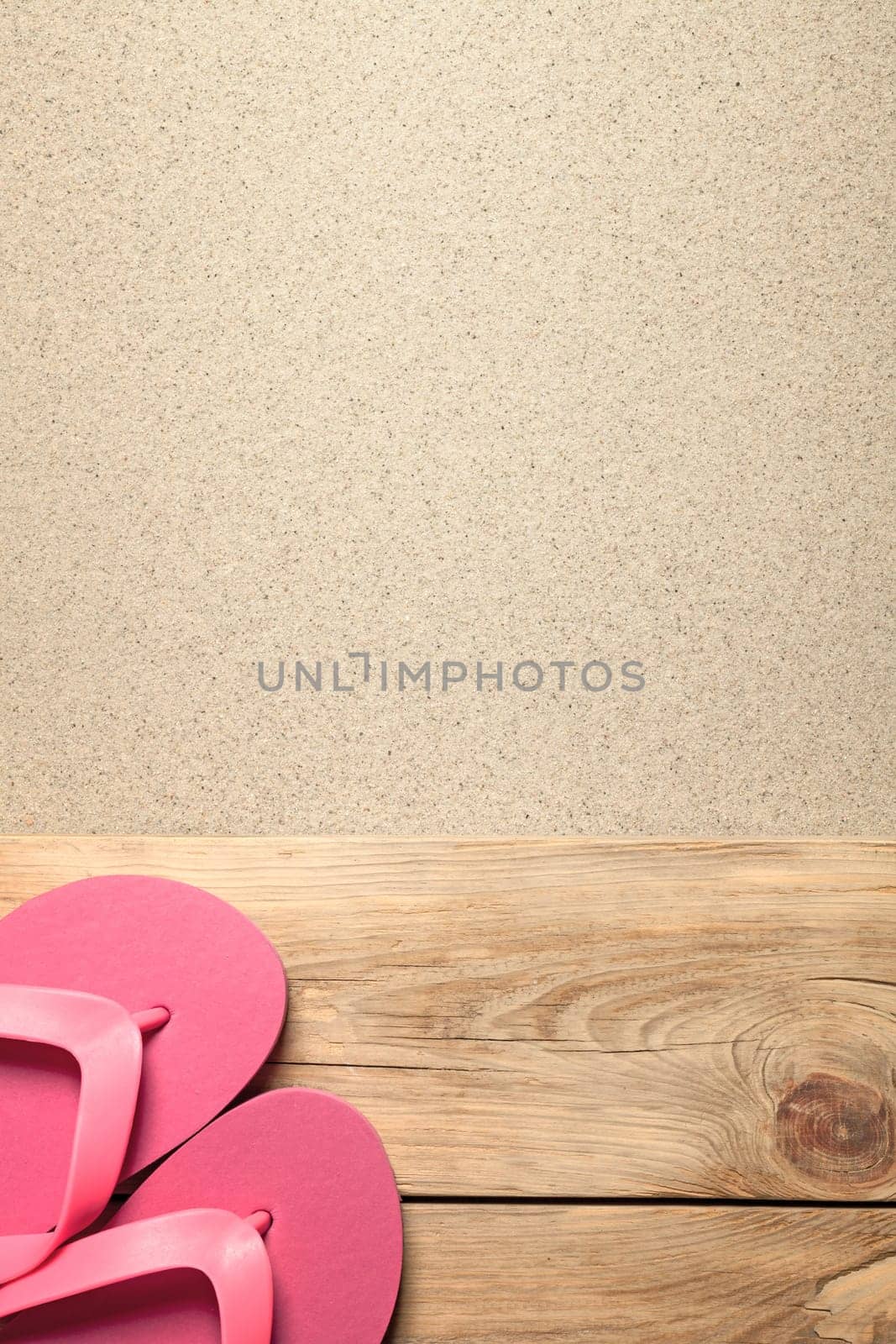 summer background with pink flip flops on sandy beach