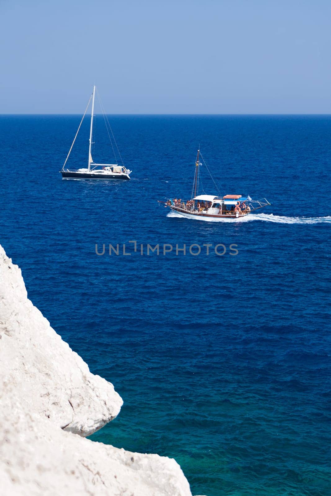 Kolymbia beach with the rocky coast in Greece. Motorboat and speed  in blue sea.