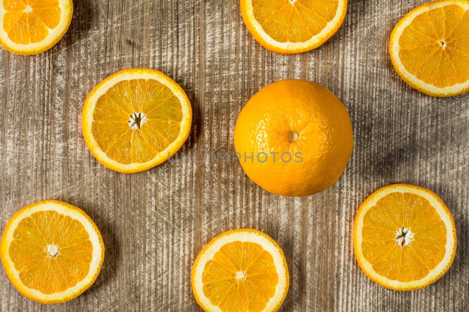 Whole orange fruit and sliced orange on wooden background