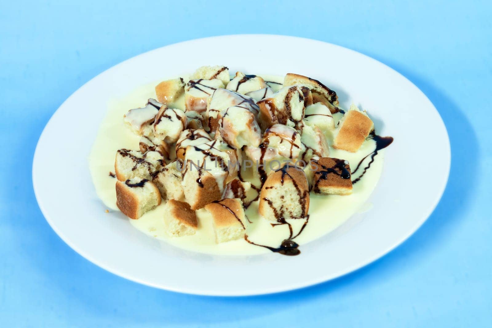 Modern food on a white plate and blue background - ducat buns with vanilla cream